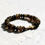 BRANSOLETKA Z CERTYFIKOWANYM BURSZTYNEM - KRZYŻYK - NA GUMCE